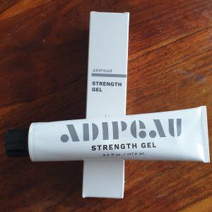 Adipeau Strength Gel and Packaging on a Table