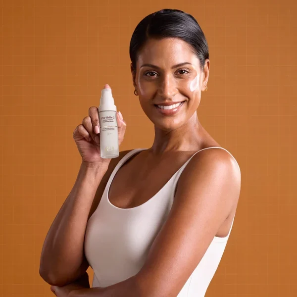Image of a woman holding The Skin diary Pro Helix C pump bottle